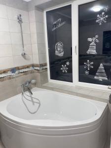 德泽姆布洛尼亚Дзембронія的带窗户的浴室内的白色浴缸