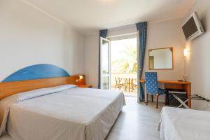巴多利诺圣马可酒店的配有一张床、一张书桌和一扇窗户的酒店客房