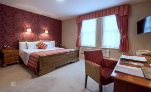 兰德林多德威尔斯大都会Spa酒店的配有一张床和一张书桌的酒店客房