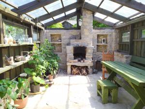 派尔努Ele kodumajutus的庭院设有石制壁炉和绿色长凳