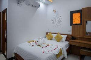 潘郎Kim Hoàn Hotel Phan Rang的一间卧室配有带白色床单和枕头的床。