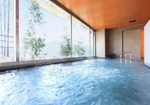 京都Urban Hotel Kyoto Gojo Premium的一座大型游泳池,位于一座带大窗户的建筑内