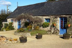 普卢加穆瓦桑Domaine Le Puits De Jeanne的石头房子,前面有蓝色的门和自行车
