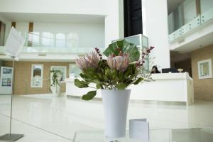 圣贝内代托-德尔特龙托翡翠套房酒店及Spa的大堂内花卉白色花瓶