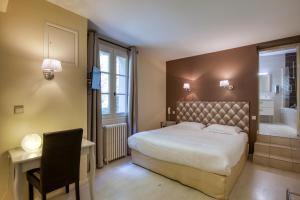 维特拉克Hôtel Restaurant Plaisance-Piscine couverte et chauffée- Proche Sarlat-的一间卧室配有一张床,浴室设有浴缸