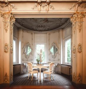 AhornRomantik Hotel Schloss Hohenstein的一间带桌椅和窗户的用餐室