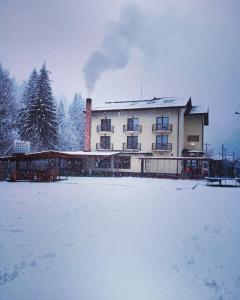 沃伊内亚萨Maison Platanus的雪地里一座大建筑,有雪覆盖的院子