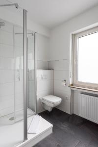 明斯特希尔图普酒店的白色的浴室设有卫生间和淋浴。
