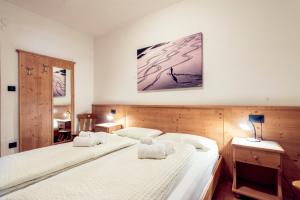博萨迪法萨Appartamenti Residence La Roggia的卧室配有两张床,墙上挂着一幅画