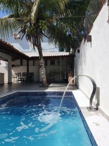 布希奥斯Casa do Tio Eri - Geribá - 100 metros da Praia的一座房子前面带喷泉的游泳池