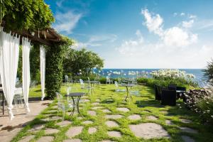 马尔法瑞维斯酒店的一个带桌椅的花园和大海