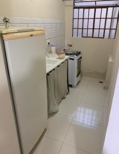 塞蒂拉瓜斯Kitnet - Apart Hotel 3的白色的厨房配有冰箱和炉灶。
