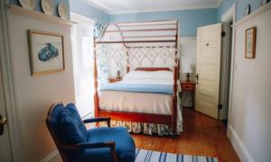 卡姆登The Belmont Inn的一间卧室配有一张床和一张蓝色椅子