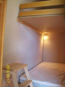 阿克斯莱泰尔姆Un Isard au Pied des Pistes的小房间设有双层床和桌子