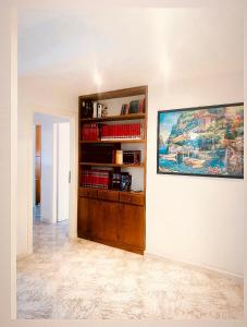 福尔米亚Via Solaro, appartamento in pieno centro的书架和墙上绘画的房间