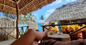 马特姆维Morningstar Bungalows Zanzibar的坐在海滩吊床上的人