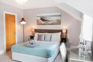 特里姆Caravogue House的一间卧室配有一张带蓝色床单和绘画的床。