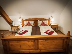 马尔贝格太阳酒店的一张大木床,配有两个红色枕头
