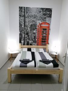 斯雷姆斯卡米特罗维察Apartmani Sirmium的红色电话亭房间的一个床位