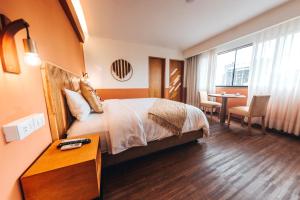 利马Selina Posada Miraflores的酒店客房配有一张床铺和一张桌子。