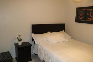 伊察LUGAR DE DESCANSO的一间卧室配有一张带白色床单和黑色床头板的床。