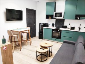 埃佩尔奈L'Atelier - Gîte & Spa的带沙发的客厅和厨房