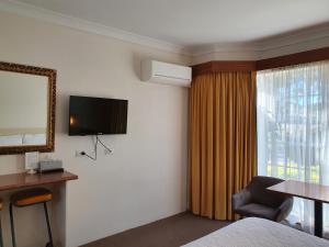 昆比恩马古丽塔汽车旅馆的酒店客房设有一张床、一台电视和一扇窗户。