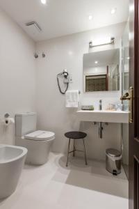 毕尔巴鄂卡尔顿酒店的白色的浴室设有卫生间和水槽。