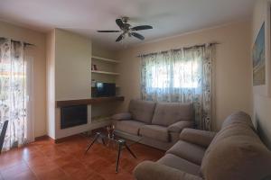 奇克拉纳－德拉弗龙特拉Villas La Barrosa的带沙发和吊扇的客厅