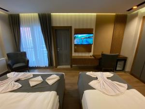 SarıkamısSarıkamış Aras Otel的酒店客房设有两张床和一台平面电视。