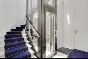 波尔多Maison Labruyère Bordeaux - Jardin Public的铺有蓝色地毯的楼梯和玻璃门