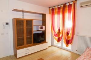 里乔内Family Residence Nuova Orchidea的客厅配有电视和窗帘