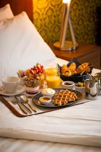 利默里克乔治利默里克酒店的床上的食品托盘,包括早餐食品