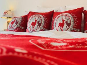 安塞热迷人的珀斯特酒店的一张带红色枕头和红色毯子的床
