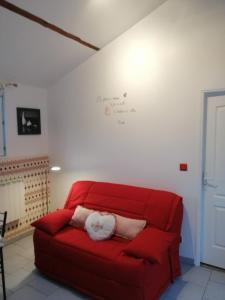 Tourville-les-Ifsgite proche etretat的红色的沙发,上面有两个白色的枕头