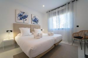 EsteponaEstepona Holiday Hills的白色的卧室设有一张大床和一个窗户