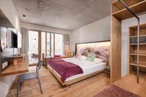 巴特霍夫加施泰因Hotel Blü Gastein的卧室配有一张白色大床和一张书桌
