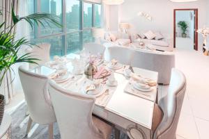 迪拜Elite Royal Apartment - Full Burj Khalifa & Fountain view - Ambassador的一间配备有白色桌椅的用餐室