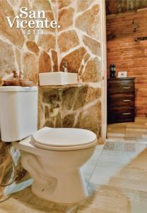 圣罗莎德卡瓦尔Hotel Termales San Vicente的浴室配有白色卫生间和石墙。