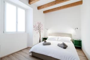 科莫Spazio 77 - The House Of Travelers的一间白色的卧室,床上有两只填充动物