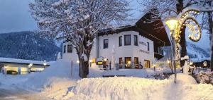 洛伊塔施Pension Gasthof Gaistal的被雪覆盖的房子