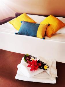 BeauregardHabitation Noelesse的两张带彩色枕头的床,床上插着鲜花