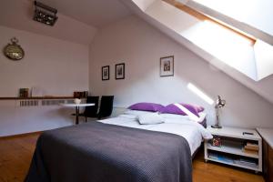 里加里加老城公寓的一间卧室配有一张带紫色枕头的床