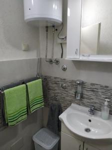 巴尼亚科维利亚查Apartman Vesna的一间带水槽和绿色毛巾的浴室