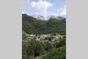 奥吕莱班T2 résidence Grand Hotel appt 102 - village thermal montagne的山谷中的一个小镇,有雪盖的山脉