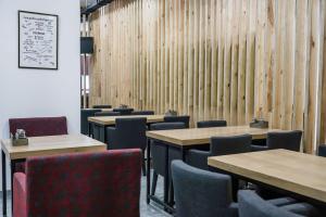 阿斯塔纳Sulu Hostel的用餐室设有桌椅和木墙