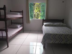 帕拉蒂Casa Aconchegante a 20 Minutos do Centro de Paraty的一间卧室设有两张双层床和一扇窗户。