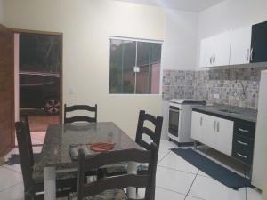帕拉蒂Casa Aconchegante a 20 Minutos do Centro de Paraty的厨房配有桌子和桌椅