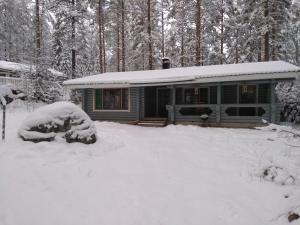 萨翁林纳Holiday Cabin Kerimaa 121的树林里积雪覆盖的房子