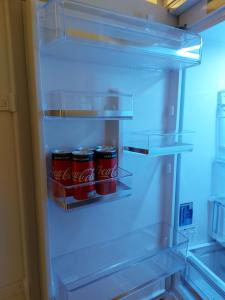 华沙Mlociny Apartment的装有苏打水罐的开放式冰箱